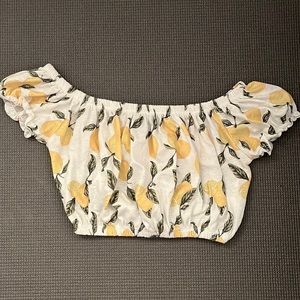 White cropped off the shoulder top with yellow lemons that have green leaves.